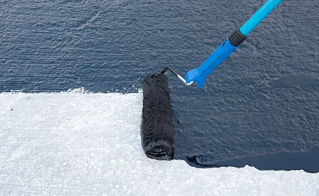 Asphalt modified bitumen being applied to a commercial flat roof